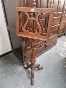 A VICTORIAN MAHOGANY DOUBLE SIDED MUSIC STAND ON COLUMN AND TRIPOD