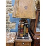 A TABLE LAMP SUPPORTED ON FOUR LARGE BOOKS AND TWO SMALLER VOLUMES, TO THE TOP OF THE SHADE. H