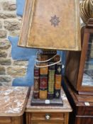 A TABLE LAMP SUPPORTED ON FOUR LARGE BOOKS AND TWO SMALLER VOLUMES, TO THE TOP OF THE SHADE. H