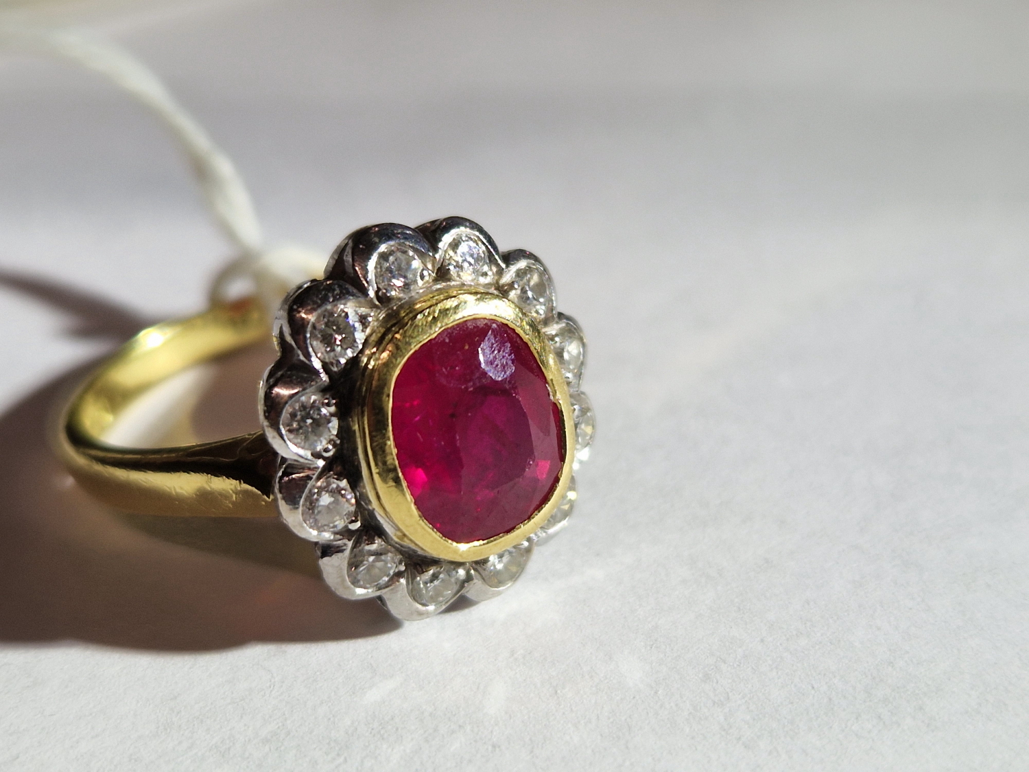 AN 18ct HALLMARKED GOLD RUBY AND DIAMOND OVAL SHAPED CLUSTER RING. THE SINGLE MEDIUM TO DARK - Image 20 of 20