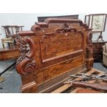 A LATE VICTORIAN BURR WALNUT DOUBLE BED WITH PANELLED ENDS FLANKED BY SCROLLING BRACKETS CARVED WITH