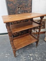 AN ARTS AND CRAFTS OAK THREE TIER TABLE, THE TURNED LEGS SUPPORTING A WOODEN GRILLE TO THE NARROW