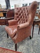 A MAHOGANY WING ARMCHAIR BUTTON UPHOLSTERED IN BROWN LEATHERETTE, CLOSE NAILING RUNNING FROM THE