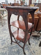 AN ART NOUVEAU MAHOGANY SIDE TABLE, THE TWO SHELVES BELOW THE TOP FRAMED BY SERPENTINE LEGS
