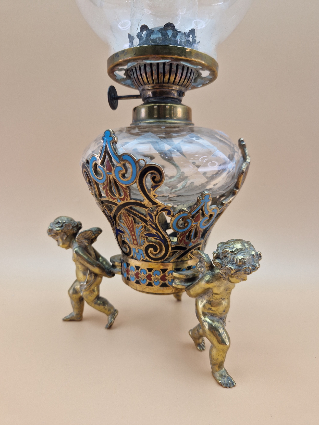 A LATE 19th C. FRENCH CLEAR CUT GLASS AND CHAMPLEVE ENAMEL OIL LAMP SUPPORTED BY THREE BRASS CUPIDS - Image 4 of 10