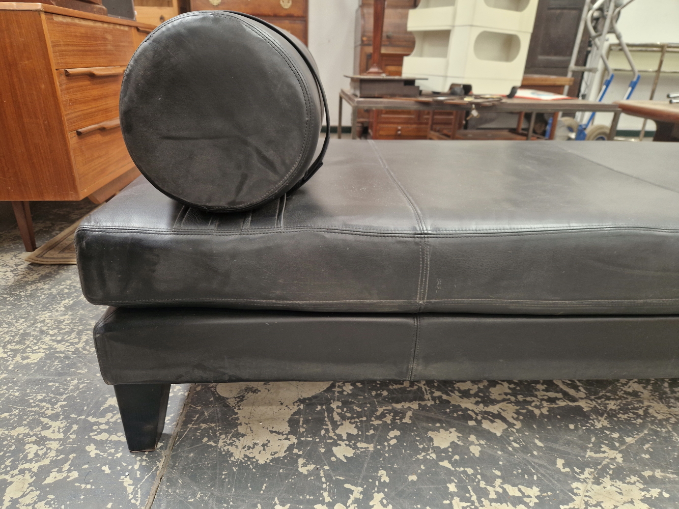 A CONTEMPORARY BLACK UPHOLSTERED CHAISE LONGUE, THE RECTANGULAR SHAPE WITH A CYLINDRICAL CUSHION END - Image 2 of 3