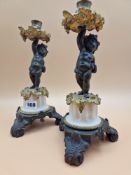 A PAIR OF LATE 19th C. BRONZE, ORMOLU AND WHITE MARBLE CANDLESTICKS HELD UP BY PUTTI STANDING ON