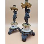 A PAIR OF LATE 19th C. BRONZE, ORMOLU AND WHITE MARBLE CANDLESTICKS HELD UP BY PUTTI STANDING ON