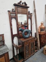 AN HALL STAND WITH BRASS COAT HOOKS EITHER SIDE OF THE MIRRORED BACK, A DRAWER ABOVE TWO DOORS