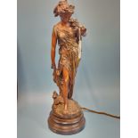 A TABLE LAMP SUPPORTED BY THE SPELTER FIGURE OF A CLASSICAL LADY HOLDING A FLOWERING STEM TO HER