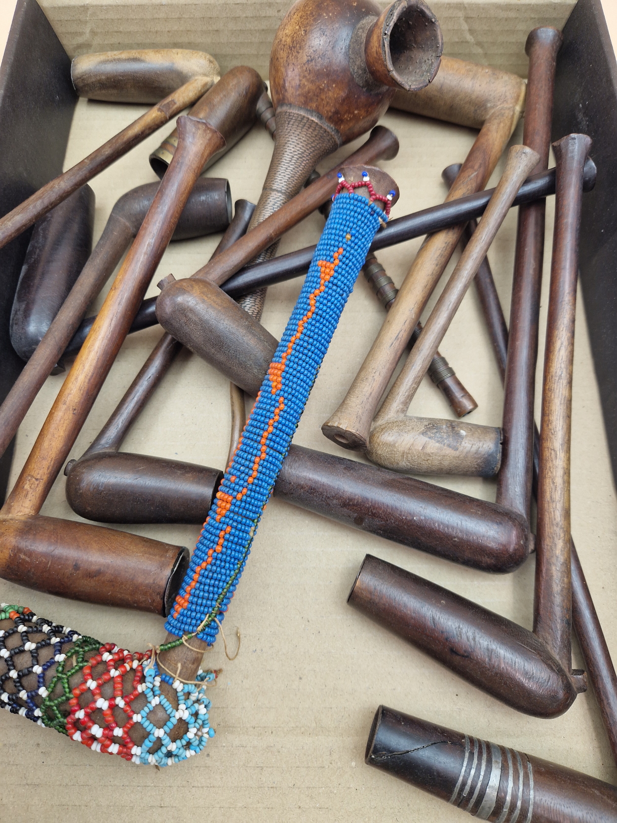 A COLLECTION OF ETHNIC WOODEN PIPES TO INCLUDE ONE MOUNTED WITH BEAD WORK AND ANOTHER WITH COPPER