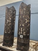 A PAIR OF CYLINDRICAL CUT METAL TABLE LAMPS PIERCED WITH FLOWERS AND FOLIAGE THROUGH TO THE WHITE