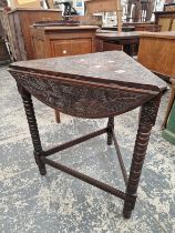 AN OAK TRIANGULAR DROP FLAP TABLE CENTRALLY CARVED WITH A ROUNDEL OF JAMES VI OF SCOTLAND WITHIN