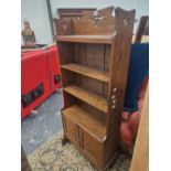 AN ARTS AND CRAFTS OAK OPEN BOOK CASE WITH A CUPBOARD BELOW THE LOWER OF FOUR SHELVES. W 56 x D 24 x
