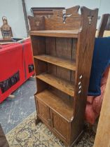 AN ARTS AND CRAFTS OAK OPEN BOOK CASE WITH A CUPBOARD BELOW THE LOWER OF FOUR SHELVES. W 56 x D 24 x