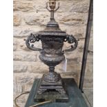 A PAIR OF BRONZE TWO HANDLED URN FORM TABLE LAMPS SUPPORTED ON SQUARE SERPENTINITE PLINTHS. H