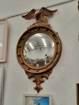 AN ANTIQUE CONVEX WALL MIRROR SURMOUNTED WITH EAGLE CREST.