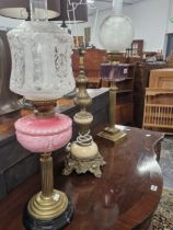 TWO OIL LAMPS WITH COLOURED GLASS RECEIVERS ON REEDED BRASS COLUMNS AND TOGETHER WITH A MARBLE AND