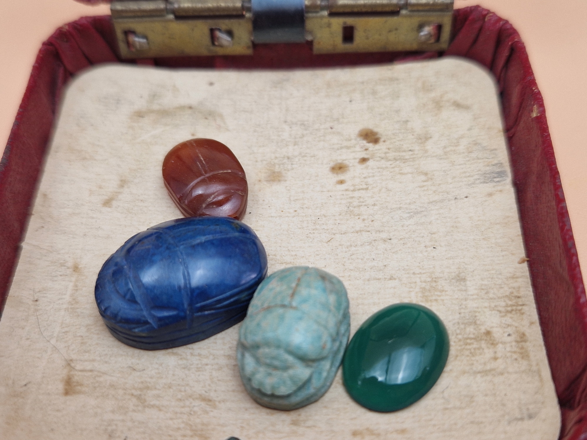 FOUR EGYPTIAN SCARABS IN CORNELIAN, LAPIS LAZULI, TURQUOISE AND GREENSTONE