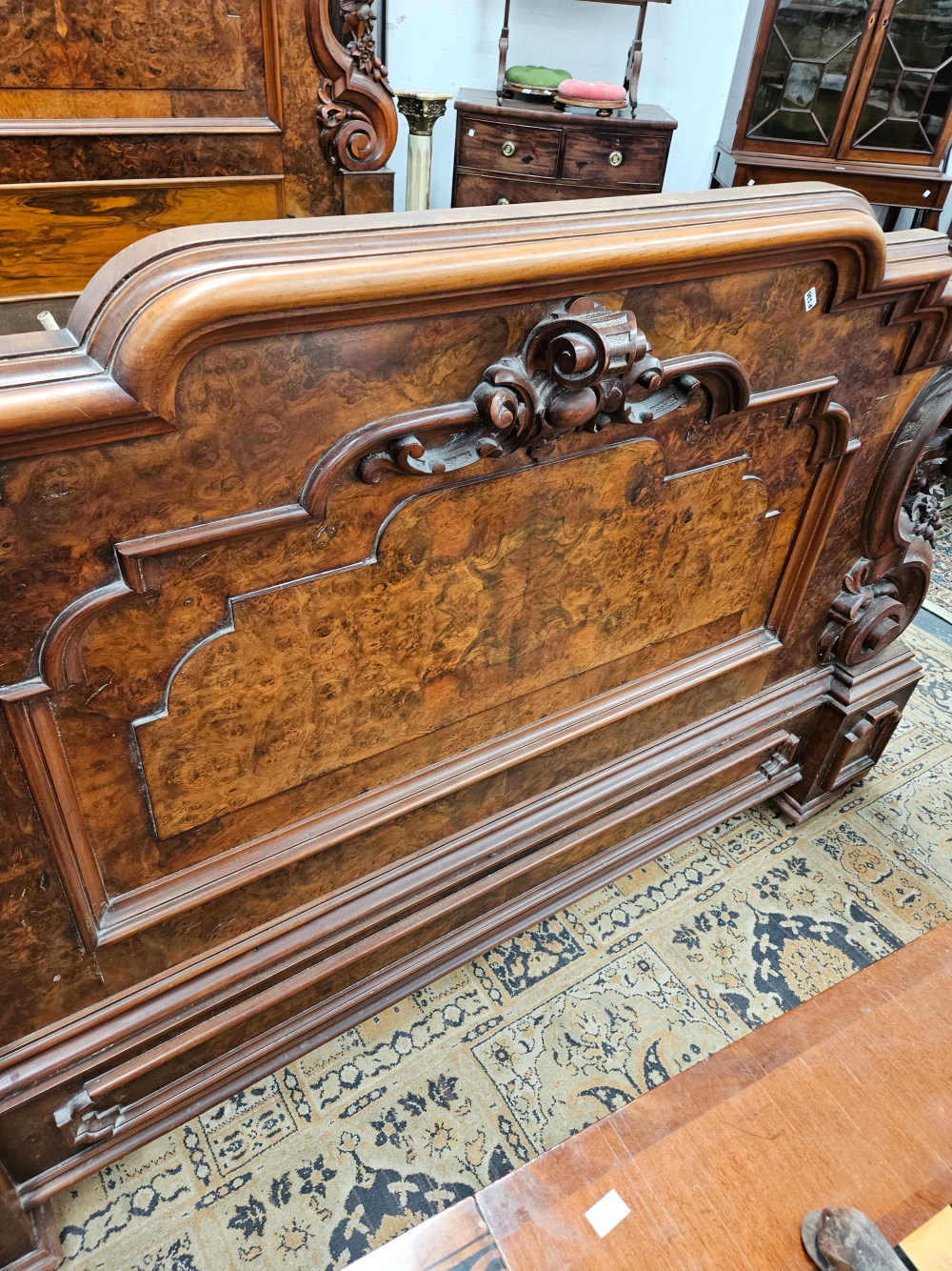 A LATE VICTORIAN BURR WALNUT DOUBLE BED WITH PANELLED ENDS FLANKED BY SCROLLING BRACKETS CARVED WITH - Image 4 of 8