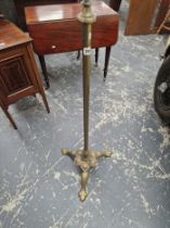 A BRASS OIL LAMP CRADLE ON A CYLINDRICAL COLUMN AND THREE TREFOIL FEET. H 117cms.