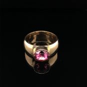 A GEM SET RING. THE WIDE RING UNHALLMARKED, ASSESSED AS 10ct GOLD, THE GEMSTONE SETTING ASSESSED