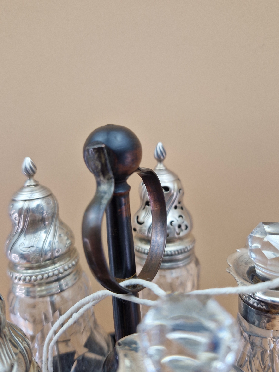 A FLORAL GILT BLACK PAPIER MACHE CRUET STAND WITH FIVE CUT GLASS BOTTLES WITH WHITE METAL MOUNTS, - Image 7 of 8