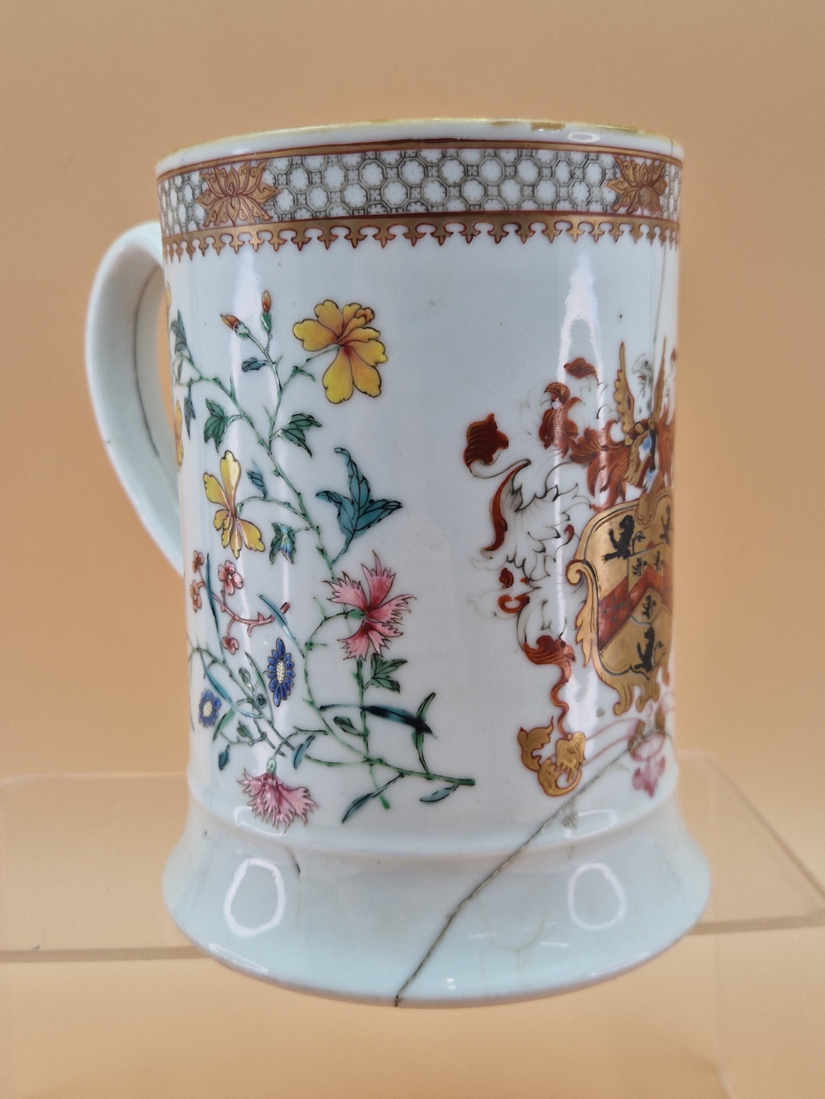A CHINESE ARMORIAL QUART MUG WITH THE ARMS PAINTED OPPOSITE THE HANDLE AND FLANKED BY FAMILLE ROSE