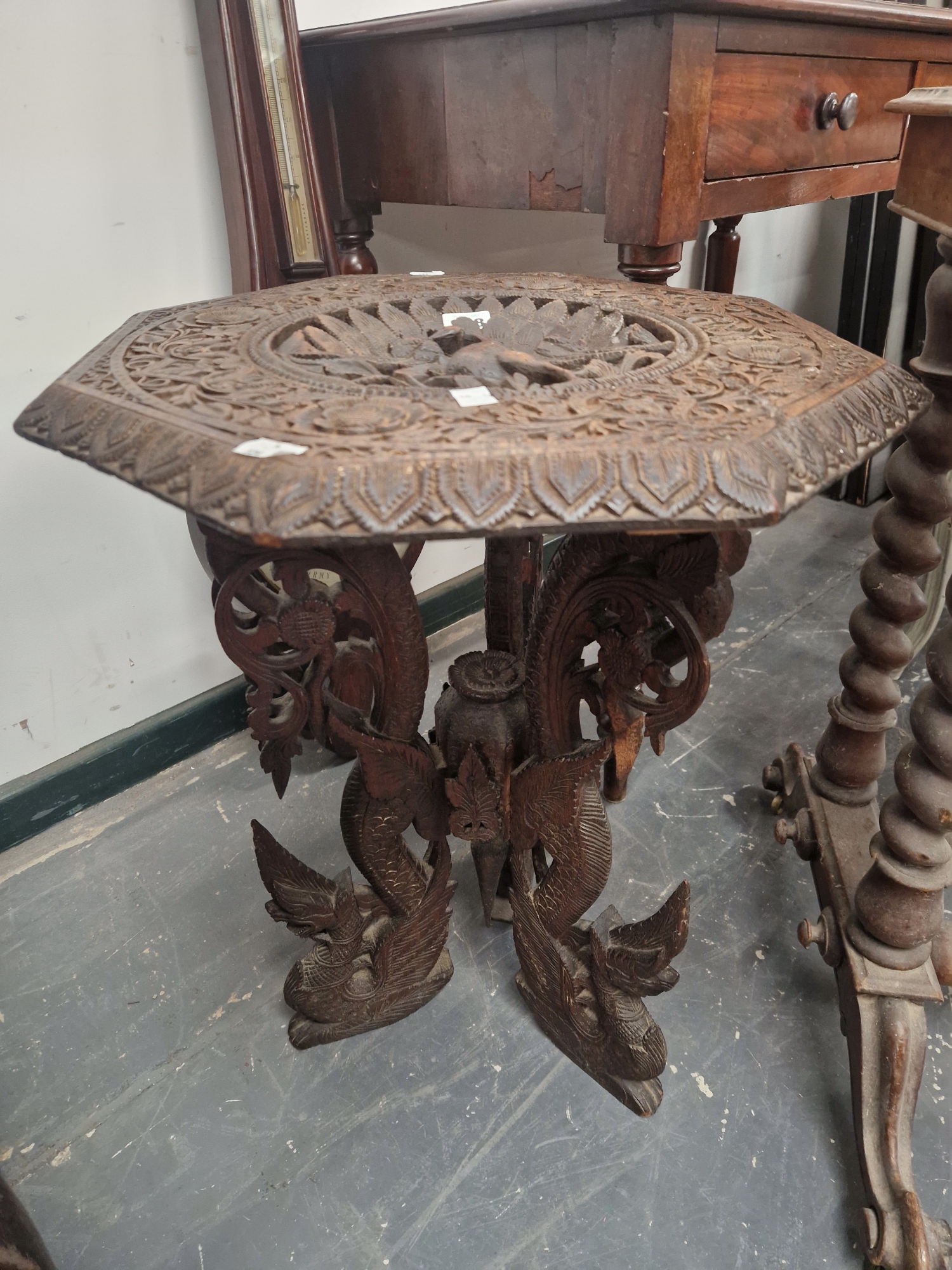 AN ISLAMIC OCTAGONAL TABLE, THE TOP PIERCED AND CARVED WITH A PEACOCK ROUNDEL, THE THREE BUTTRESS