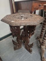 AN ISLAMIC OCTAGONAL TABLE, THE TOP PIERCED AND CARVED WITH A PEACOCK ROUNDEL, THE THREE BUTTRESS