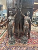 A PAIR OF BRONZE FIGURAL STANDARD LAMPS, EACH TORCH SHAPE HELD UP BY A SCANTILY DRAPED CLASSICAL