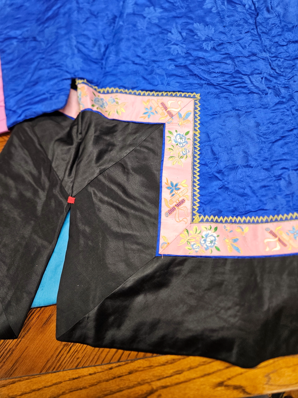 A CHINESE QUILTED DEEP BLUE AND BLACK SILK JACKET EDGED WITH A PINK GROUND FLORAL BAND - Image 21 of 27