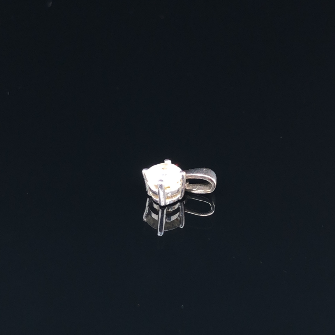 A 9ct HALLMARKED WHITE GOLD DIAMOND SINGLE STONE ROUND BRILLIANT CUT PENDANT HELD IN A FOUR CLAW