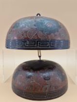 A GRADED SET OF TWO CHINESE SINGING BOWLS DECORATED WITH PEONIES ON A RED GROUND, THE SUSPENSION