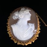 AN ANTIQUE CARVED SHELL CAMEO MOUNTED BROOCH DEPICTING A MAIDEN WITH FLOWING HAIR WITH AN ANCHOR