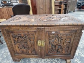 AN EASTERN CARVED CAMPHORWOOD SIDE CABINET WITH FITTED DRAWERS TO INTERIOR.