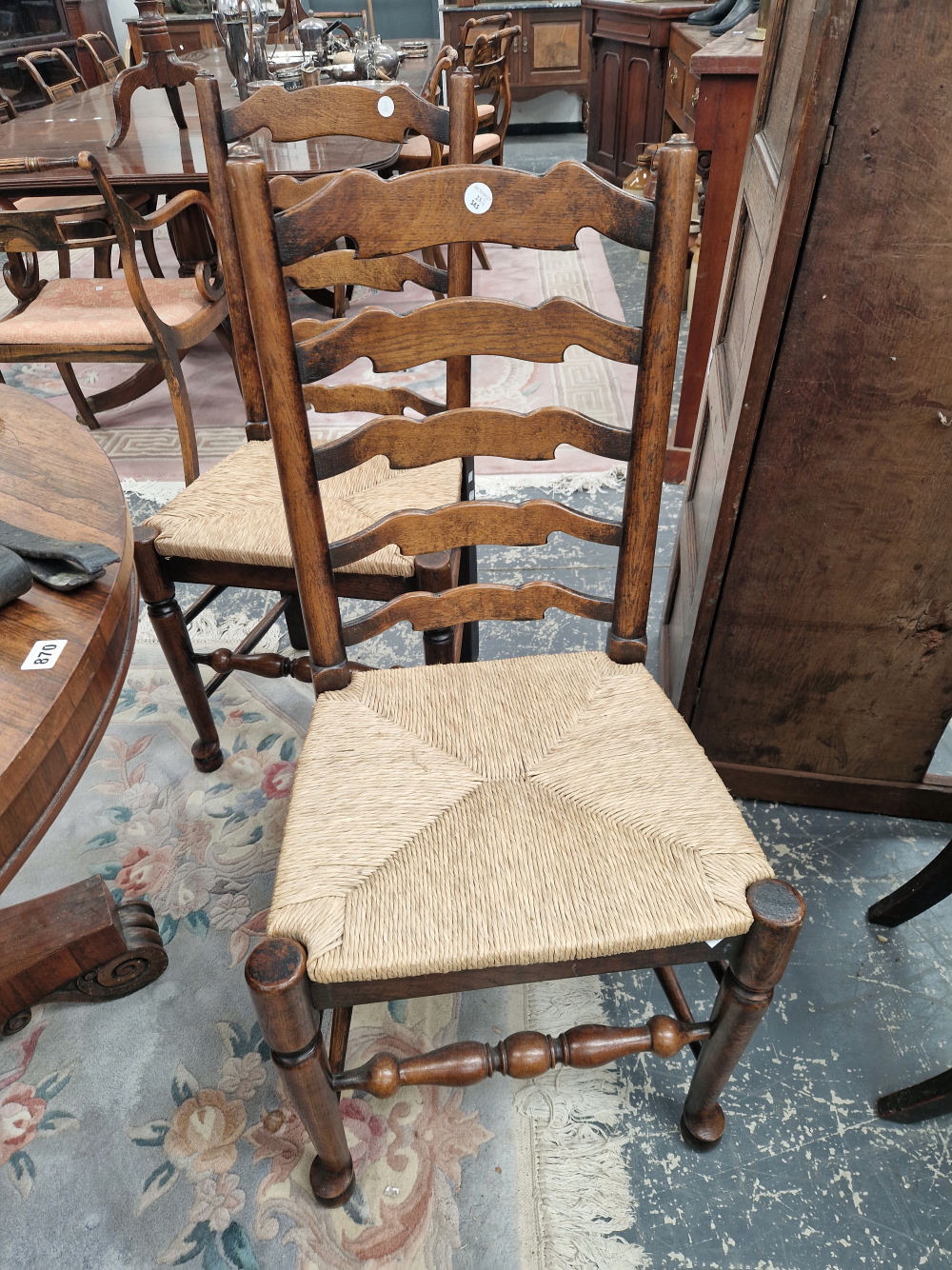 A SET OF SIX OAK LADDER BACK CHAIRS WITH RUSH DROP IN SEATS