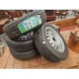 A SET OF FOUR VINTAGE CAR WHEELS WITH NEW TYRES.