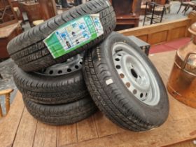 A SET OF FOUR VINTAGE CAR WHEELS WITH NEW TYRES.