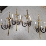 A SET OF FOUR BLACKENED AND POLISHED BRONZE TWO BRANCH WALL LIGHTS, THE REEDED BACK PLATES WITH