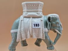 A ROYAL WORCESTER GLAZED PARIAN CELADON COLOURED ELEPHANT CAPARISSONED WITH A WHITE HOWDAH. H