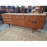 A 1970S TEAK SIDEBOARD, THE CENTRAL PULL DOWN DOOR FLANKED BY THREE DRAWERS AND BY TWO DOORS ABOVE