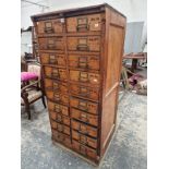 AN OAK VINTAGE CABINET OF TWO BANKS OF TEN DRAWERS EACH TO TAKE DIVISIONS TO FORM COMPARTMENTS.