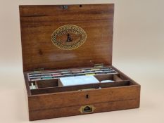A LATE VICTORIAN REEVES MAHOGANY PAINT BOX CONTAINING UNUSED BLOCKS OF PAINT, CERAMIC PALETTES IN
