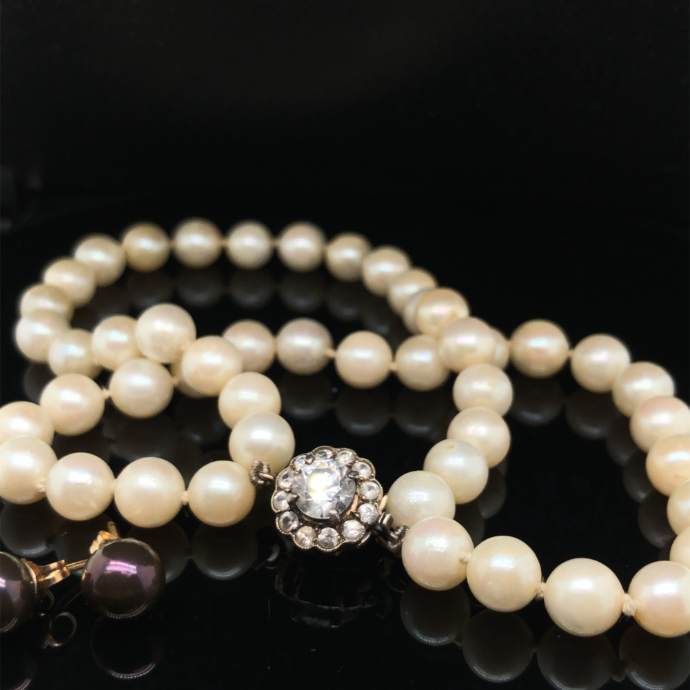 A TWO ROW CULTURED PEARL BRACELET WITH A CZ SET CLASP, STAMPED 375, ASSESSED AS 9ct WITH A LOW GRADE