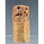 A CHINESE PINK/BROWN SOAPSTONE CYLINDRICAL SEAL PIERCED AND CARVED WITH DRAGONS CHASING A PRECIOUS