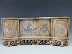 A CHINESE STONE TABLE TOP CABINET, THE TWO CENTRAL SLIDING DOORS AND FLANKING ROUNDED CUPBOARDS