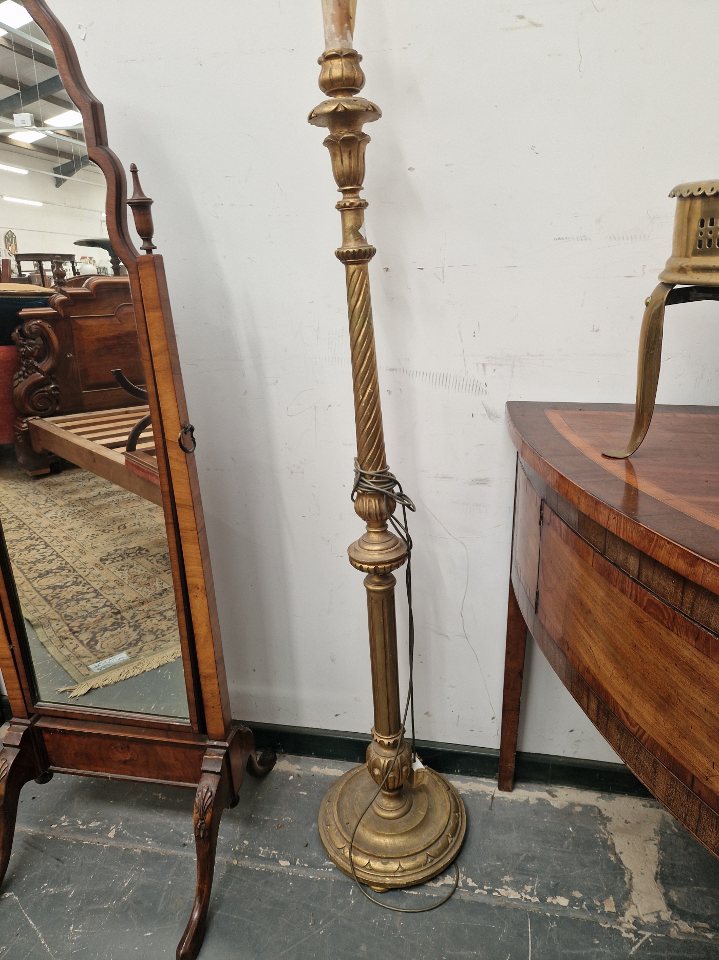 A GILT WOOD CANDLESTICK STANDARD LAMP WITH A SPIRALLY TURNED TOPPED COLUMN ON A CIRCULAR FOOT