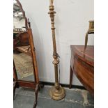 A GILT WOOD CANDLESTICK STANDARD LAMP WITH A SPIRALLY TURNED TOPPED COLUMN ON A CIRCULAR FOOT