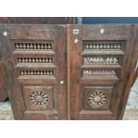 A PAIR OF OAK CUPBOARD DOORS, EACH PIERCED WITH THREE BANDS OF BALUSTRADES ABOVE BALUSTERS IN